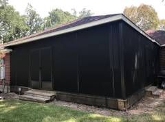 Windcrest screen room built with a bright insulated roof and full‑height screen walls to create a cool, breezy outdoor living area.