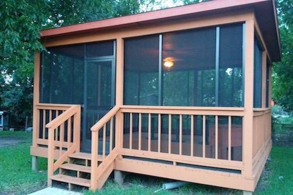 Timberwood Park screen room featuring an insulated roof and dark bronze framing that complements stone‑accent homes.