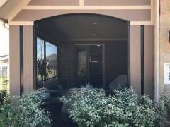 Lakeway screen room built with wide‑span screen panels to preserve hilltop views while keeping the space bug‑free.