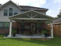 Covered patio with privacy wall and mounted TV in Fentress, TX