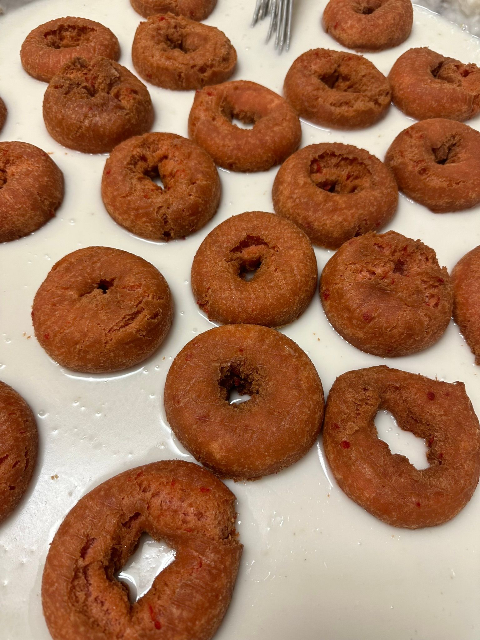 a bunch of donuts are sitting on top of a white surface .