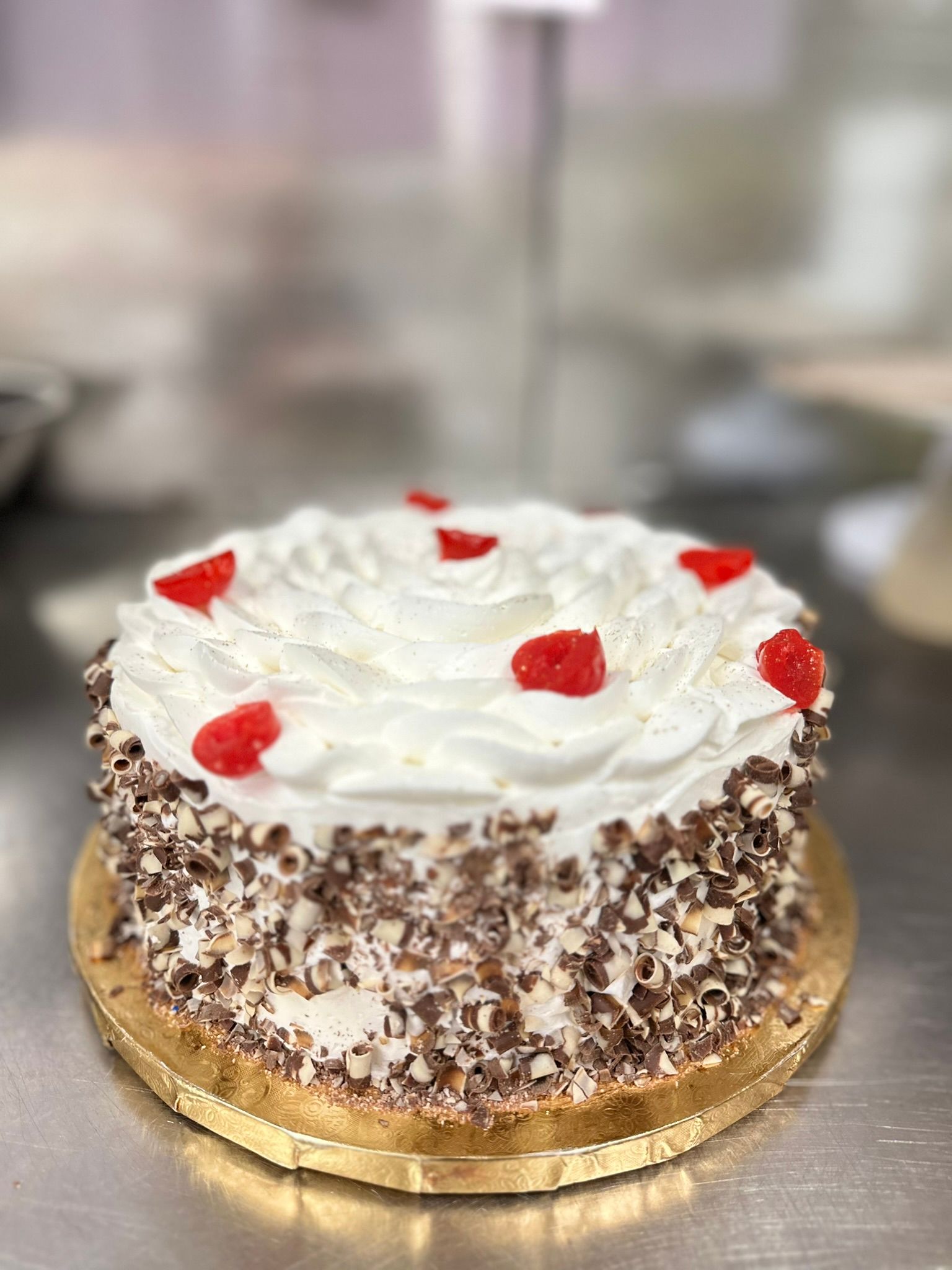 a black forest cake with whipped cream and cherries on top is sitting on a table .