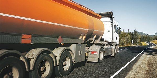 A tanker truck is driving down a highway.