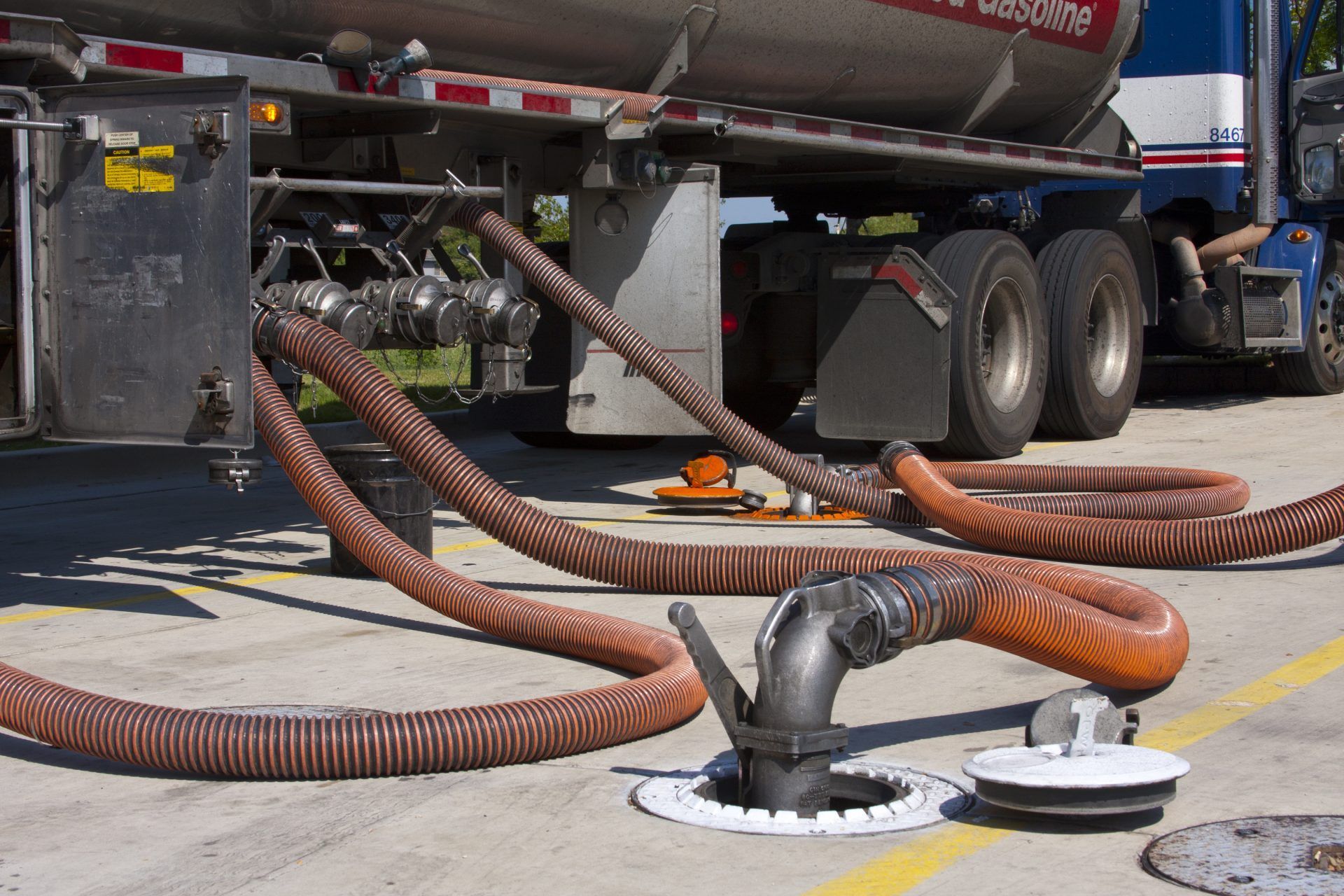 A truck is being fueled with hose attached to it