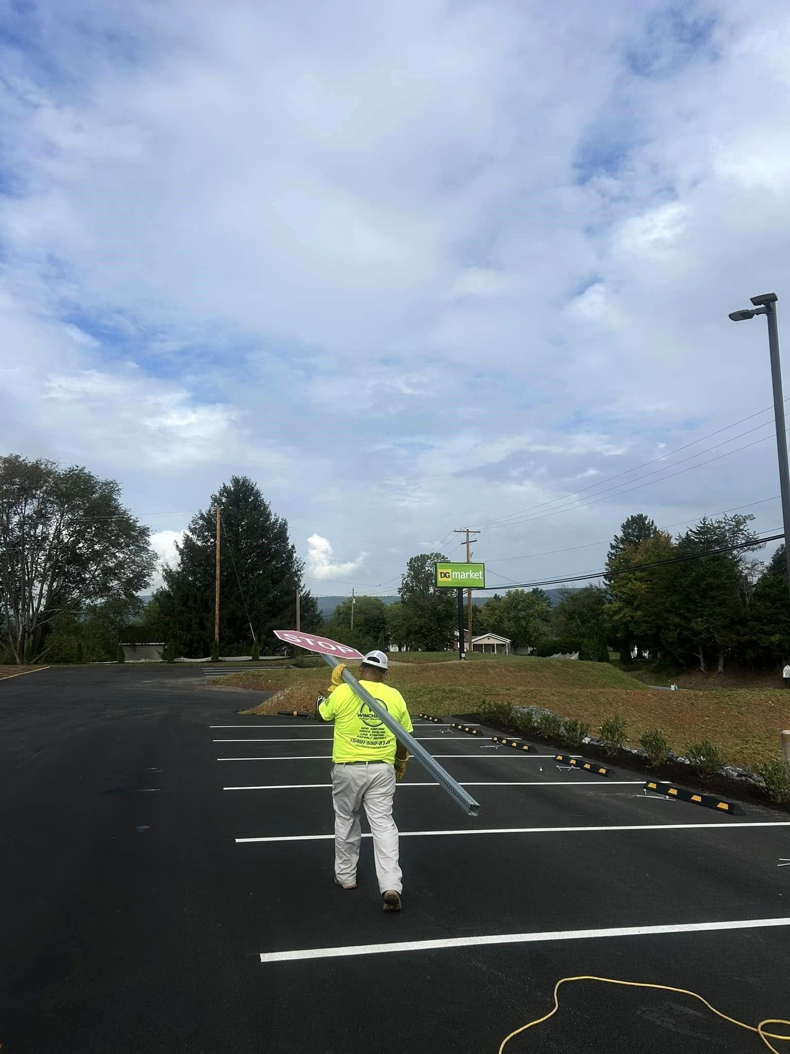 Image of Winchester Striping installing singage in a parking lot.