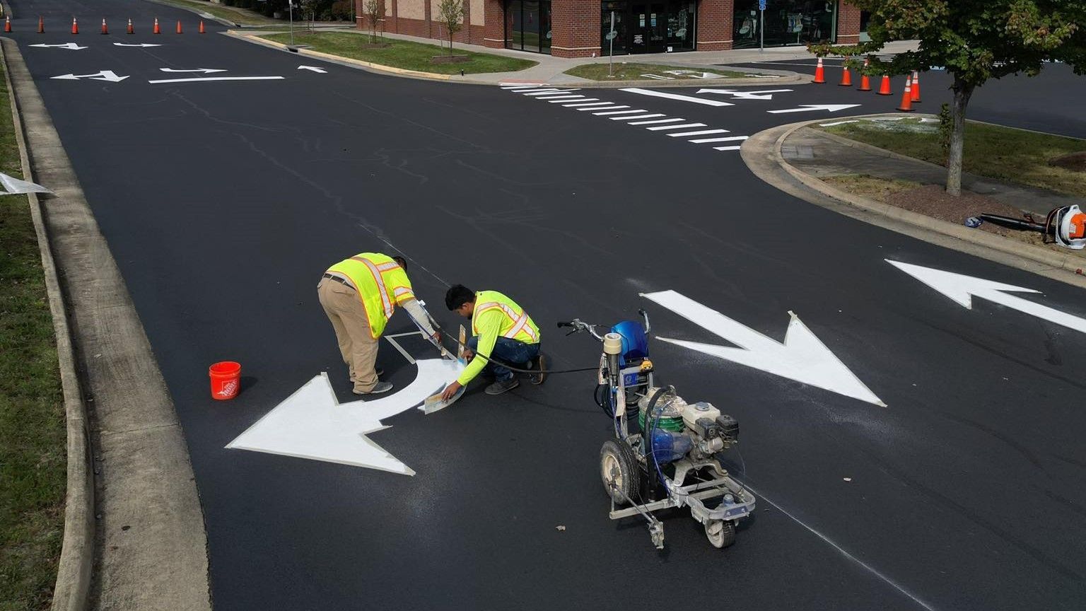 Image of striping people painting arrow markers on the road in a street in Virginia.