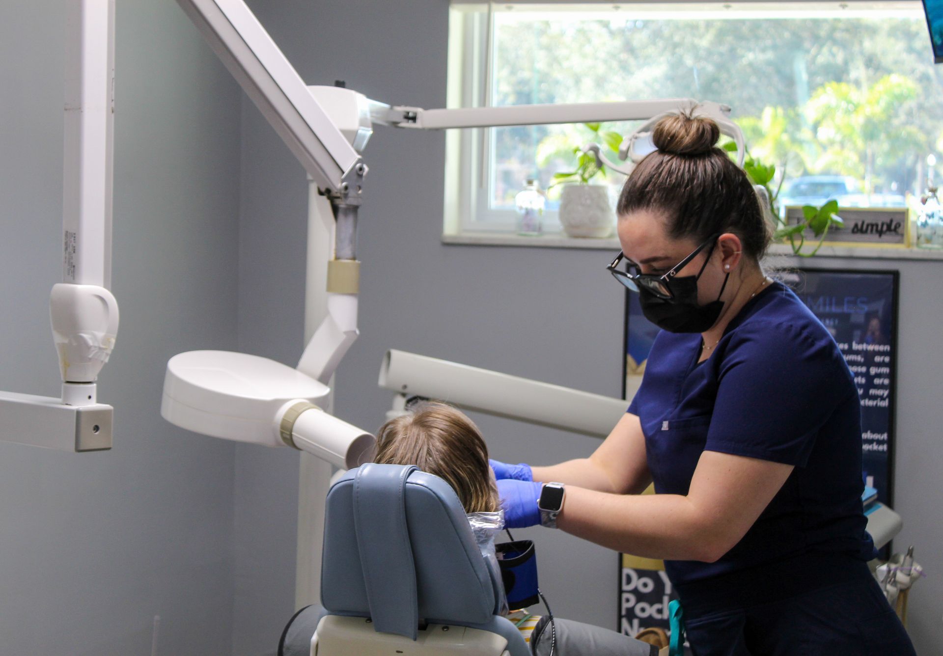 Hygienist treating a patient in chair