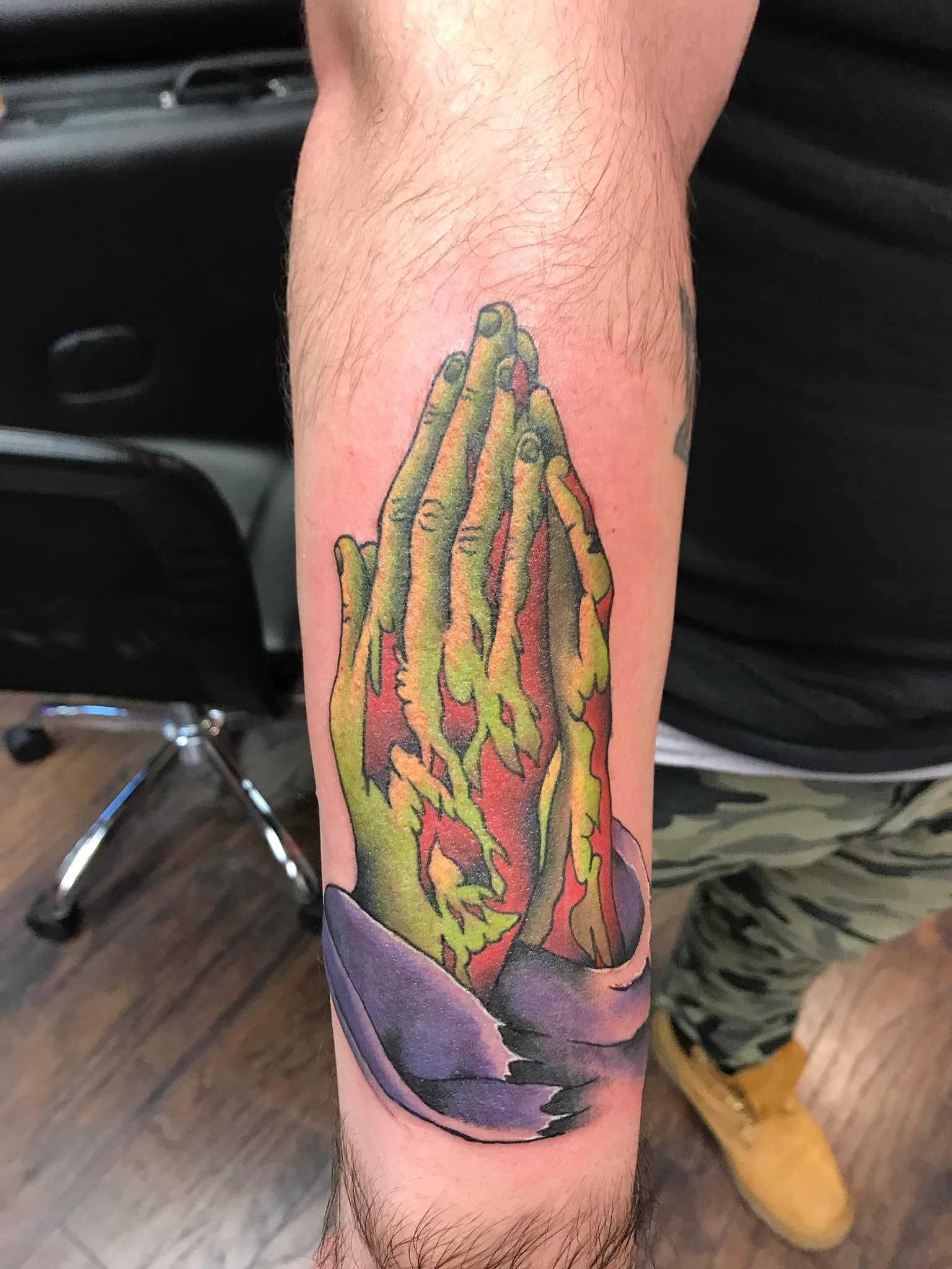 Tattoo by Eric Estrada at The Widow's Son Tattoo Co. in Gilbertsville, PA — praying hands in full colour on a forearm