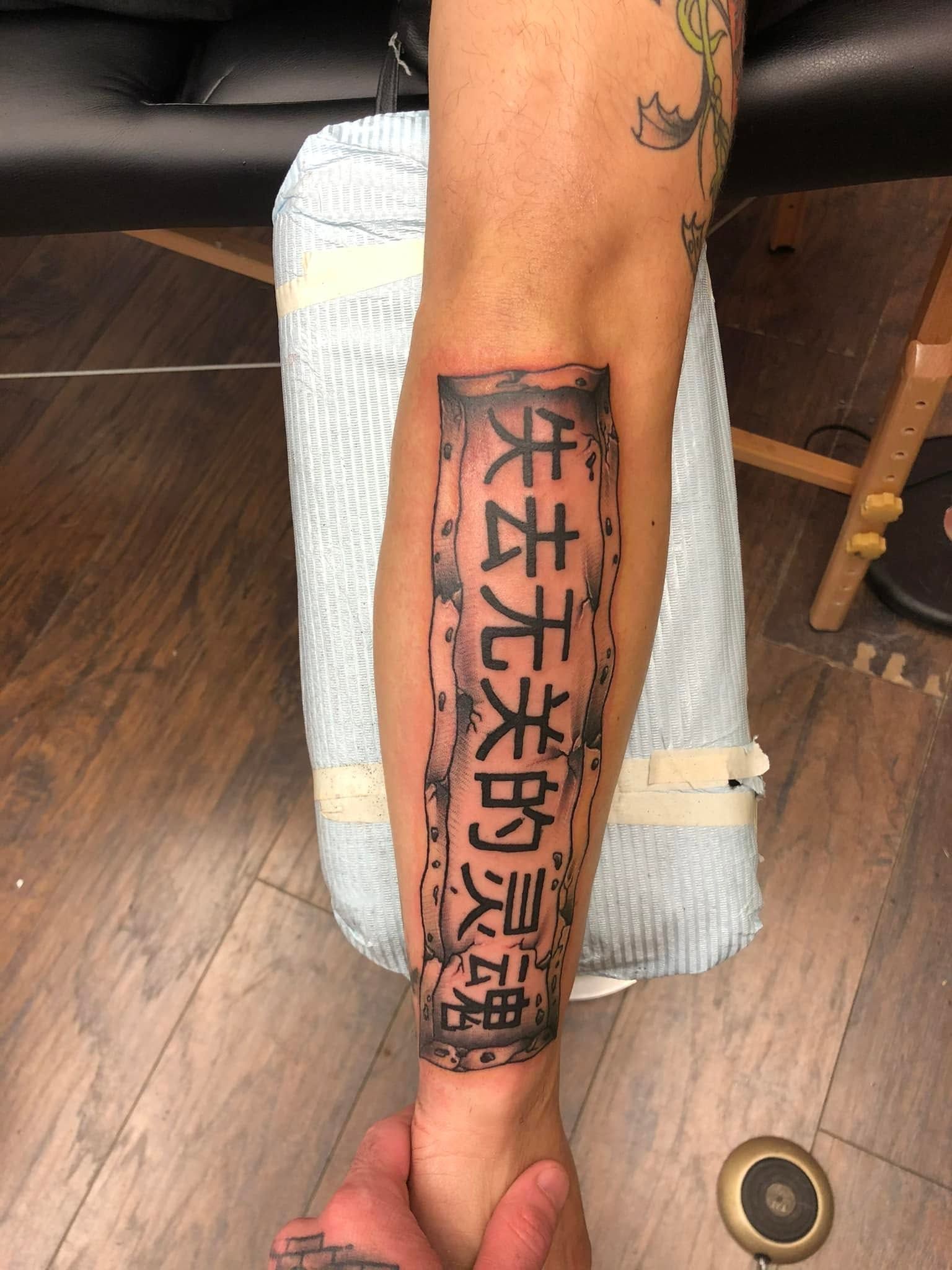 Tattoo by Eric Estrada at The Widow's Son Tattoo Co. in Gilbertsville, PA — black and grey lettering down a calf