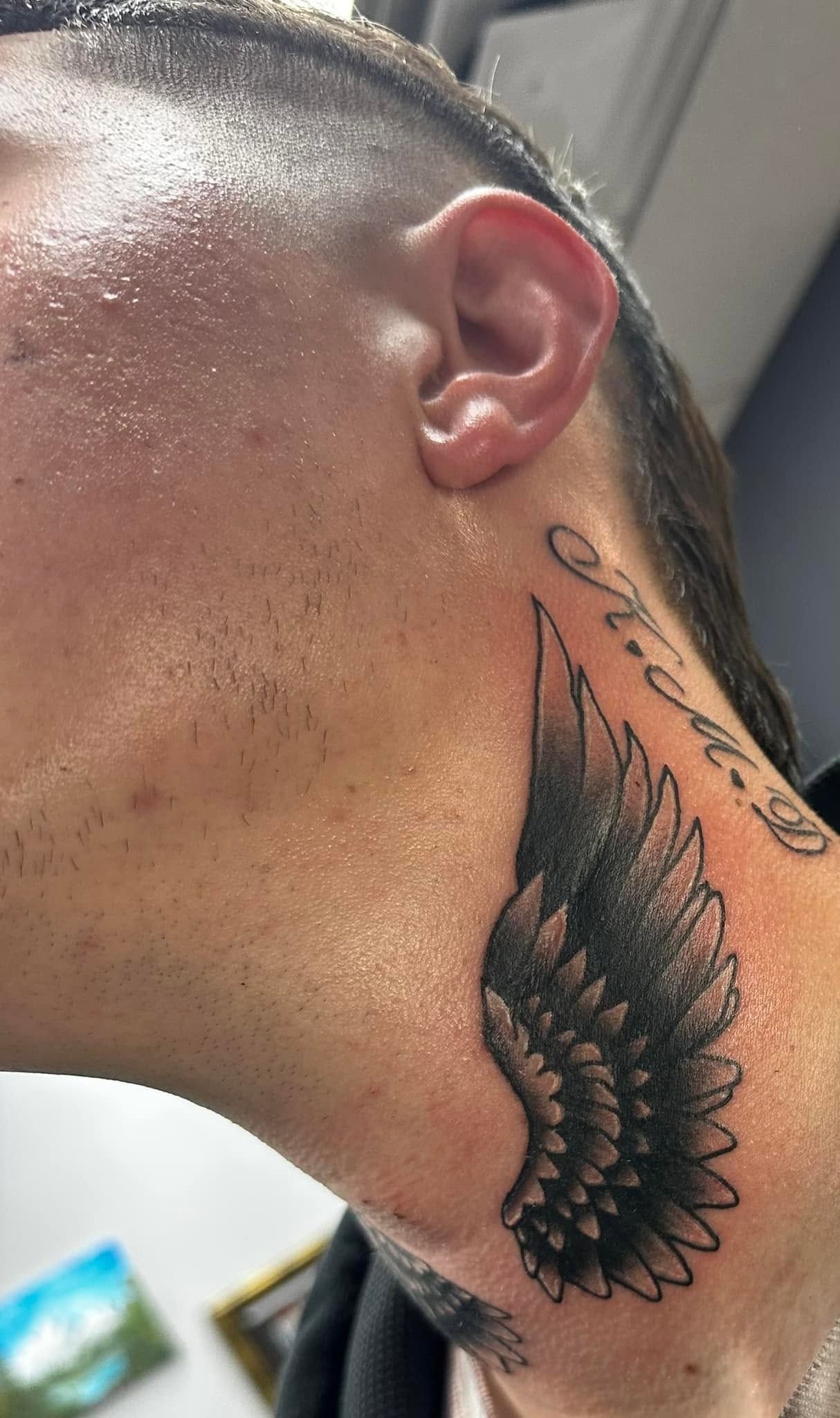 Tattoo by Eric Estrada at The Widow's Son Tattoo Co. in Gilbertsville, PA — script and a wing running down the neck