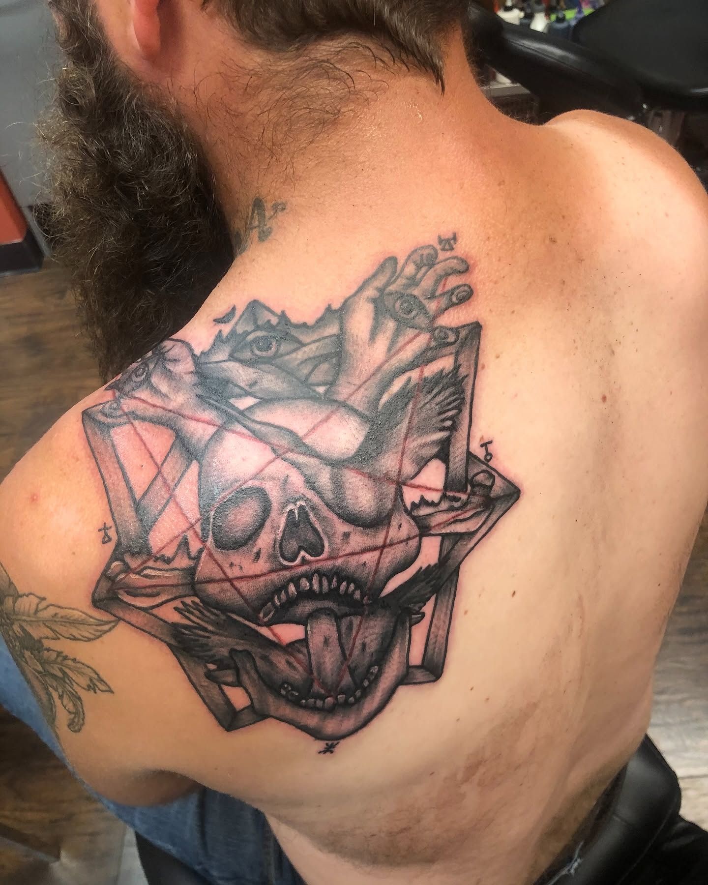 Tattoo by Eric Estrada at The Widow's Son Tattoo Co. in Gilbertsville, PA — a black and grey demon mask across a chest