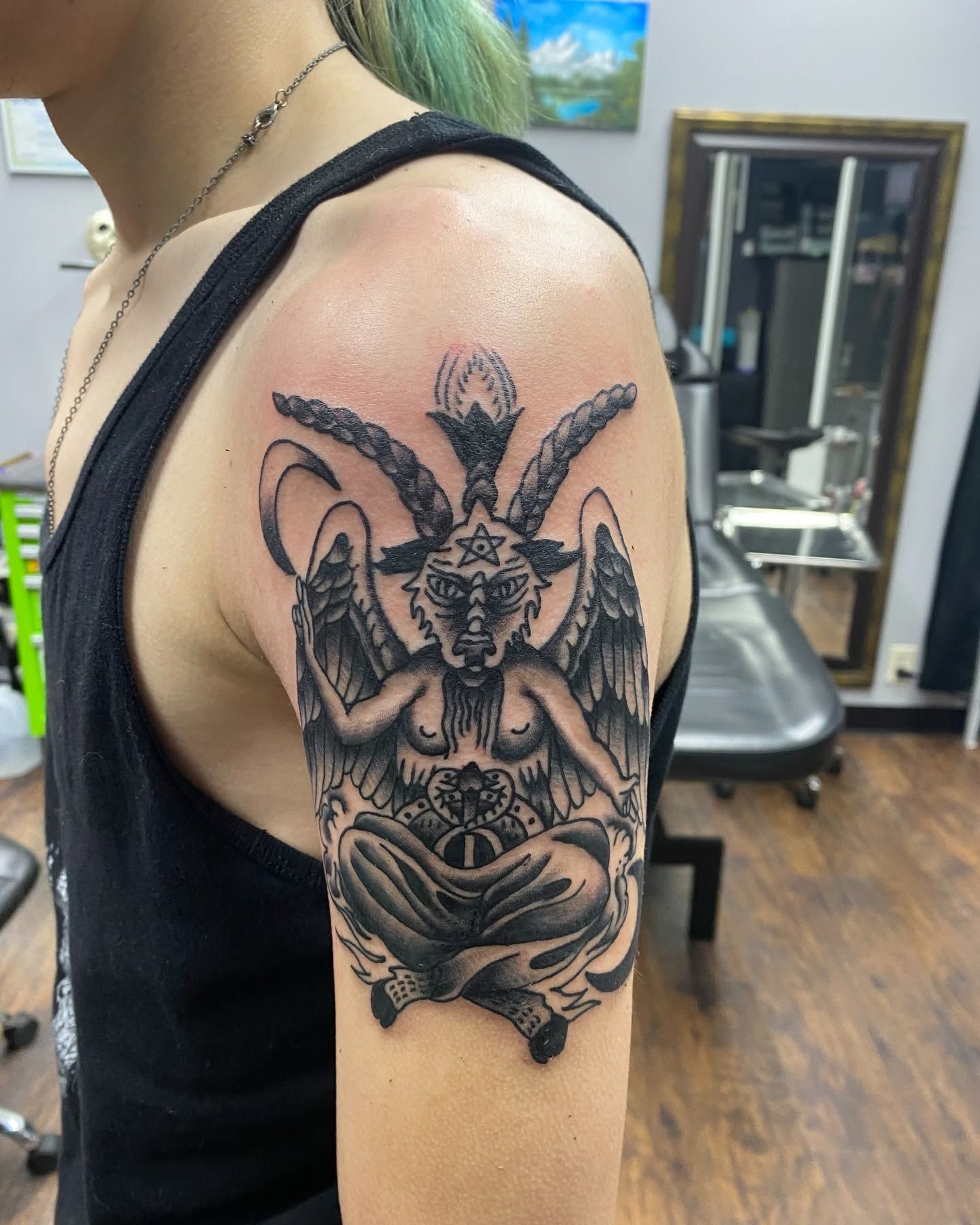 Tattoo by Eric Estrada at The Widow's Son Tattoo Co. in Gilbertsville, PA — a black and grey seated figure on an upper arm