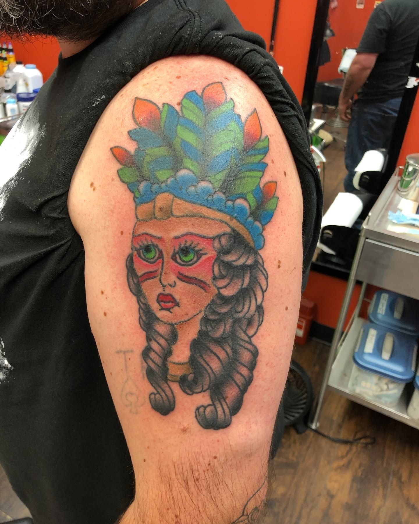 Tattoo by Eric Estrada at The Widow's Son Tattoo Co. in Gilbertsville, PA — a colour portrait in a feathered headdress on a shoulder