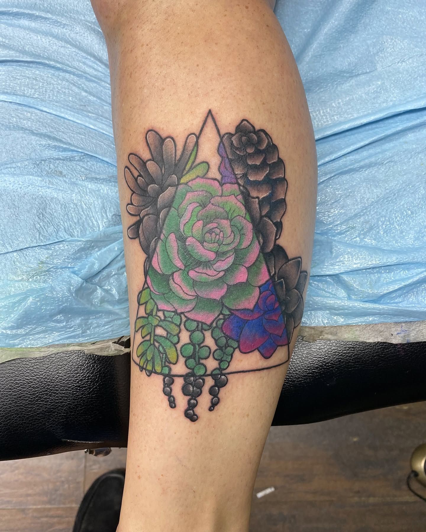 Tattoo by Eric Estrada at The Widow's Son Tattoo Co. in Gilbertsville, PA — roses in colour inside a geometric frame on a calf