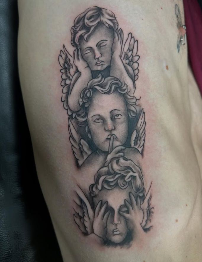Tattoo by Tom Kelly at The Widow's Son Tattoo Co. in Gilbertsville, PA — black and grey cherubs on the ribs