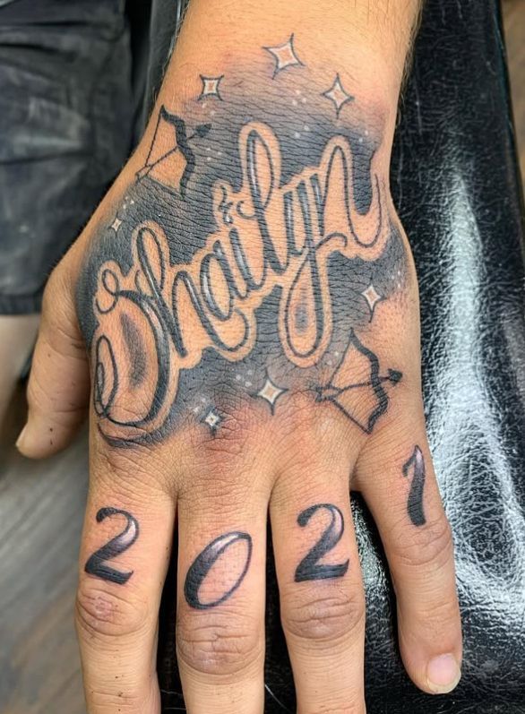 Tattoo by Tom Kelly at The Widow's Son Tattoo Co. in Gilbertsville, PA — a name in outlined lettering across a hand
