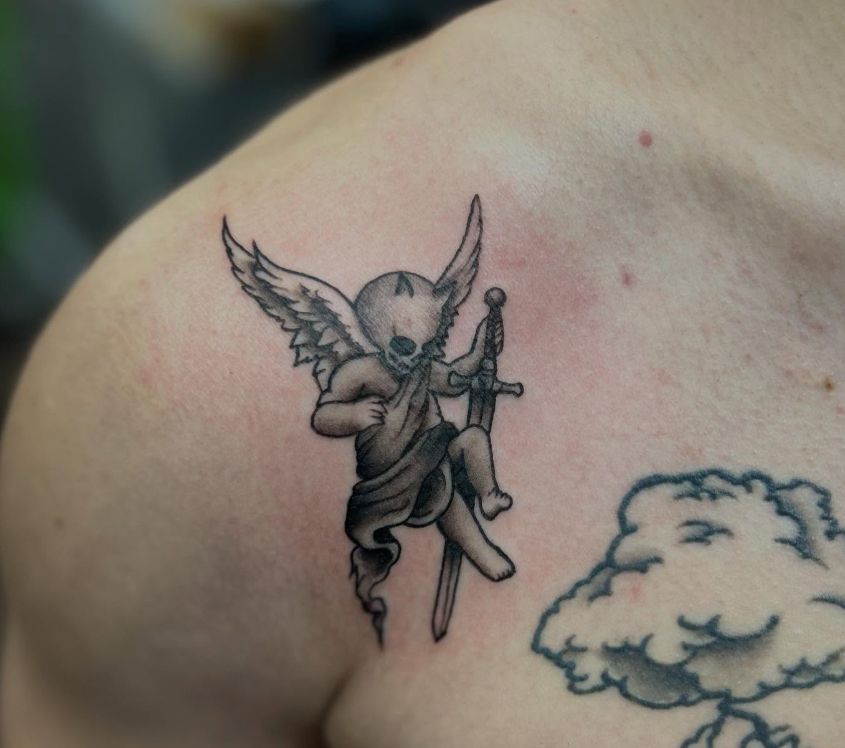 Tattoo by Tom Kelly at The Widow's Son Tattoo Co. in Gilbertsville, PA — a black and grey angel among clouds