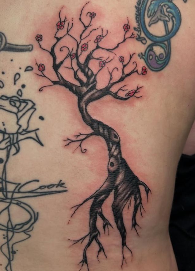 Tattoo by Tom Kelly at The Widow's Son Tattoo Co. in Gilbertsville, PA — a bare tree in red blossom with exposed roots