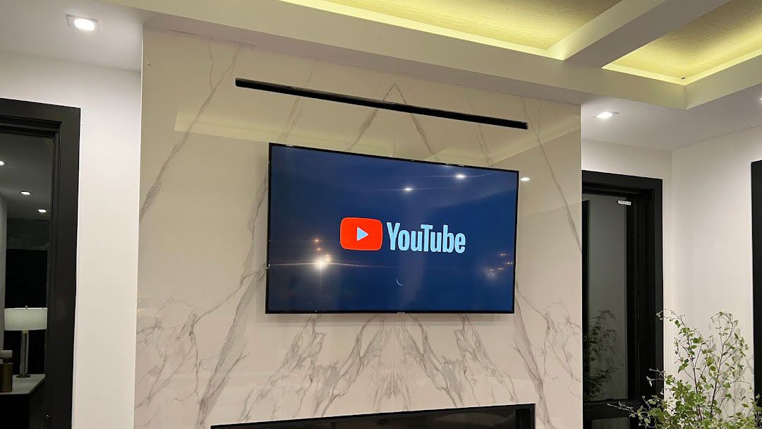 A living room with a fireplace and a tv mounted on the wall.