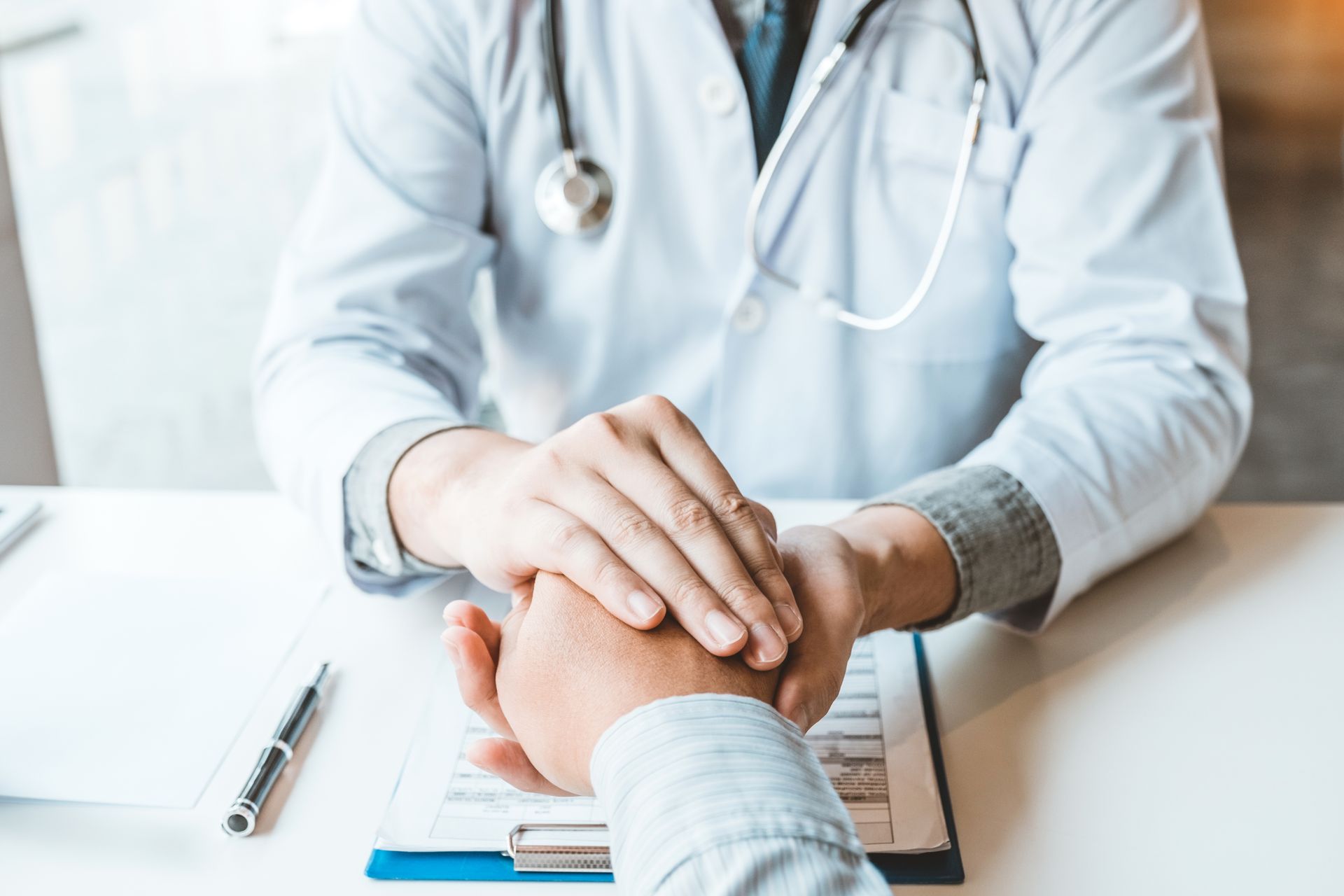 Physician holding hands for comforting patient at hospital. Physician holding hands for comforting patient at hospital.