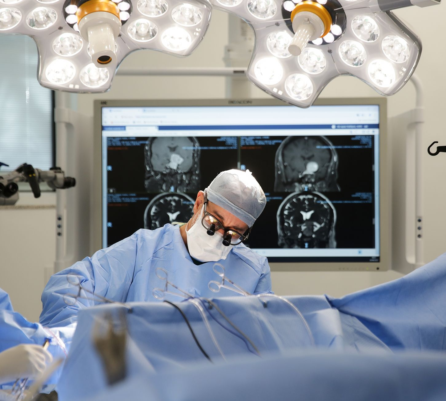 Equipe médica realizando cirurgia em uma sala de cirurgia bem iluminada.