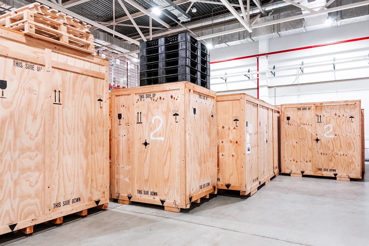 Custom wooden crates stacked in a warehouse, ready for shipping industrial equipment.