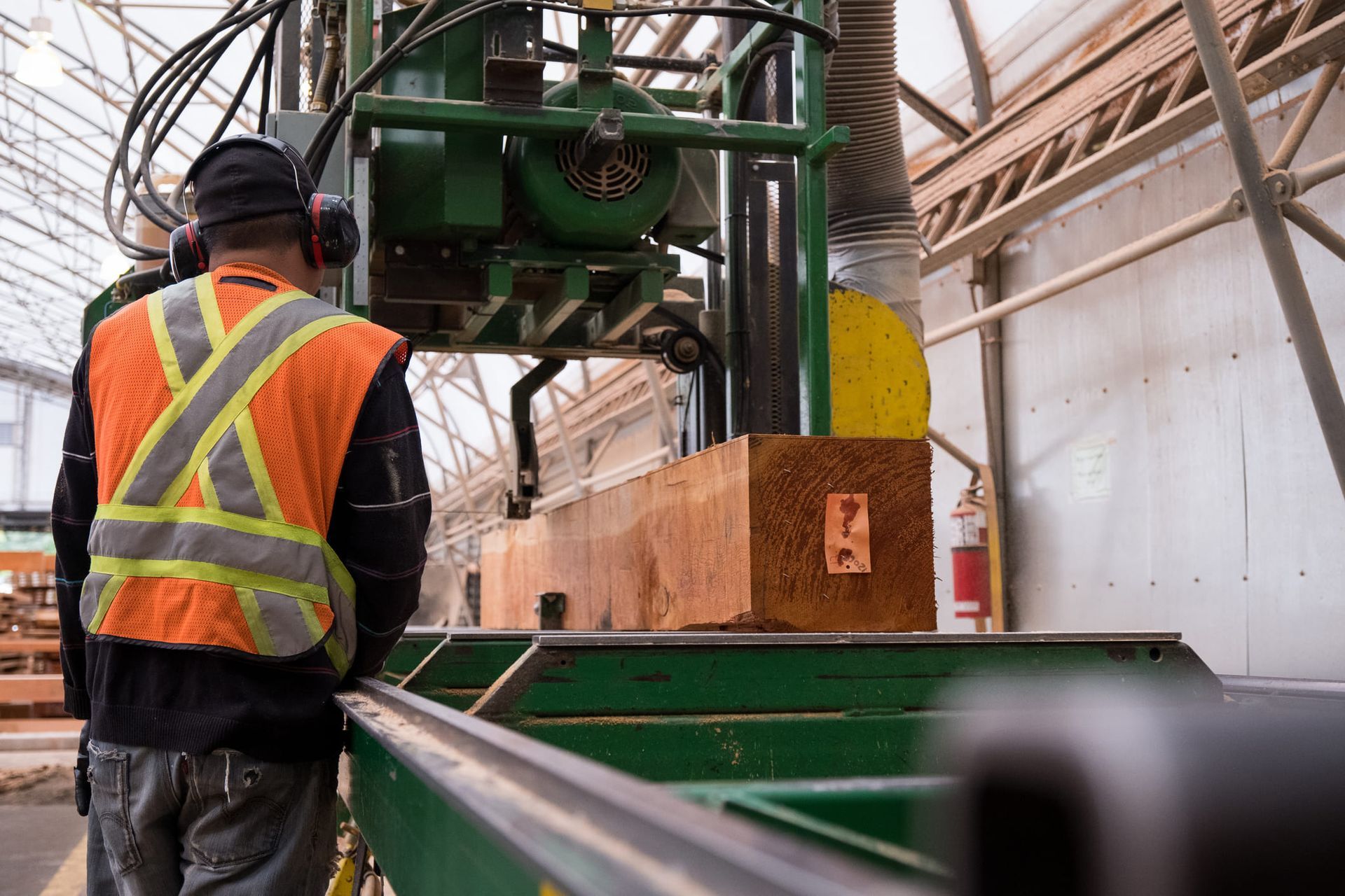 A man is standing in front of a machine in a factory.