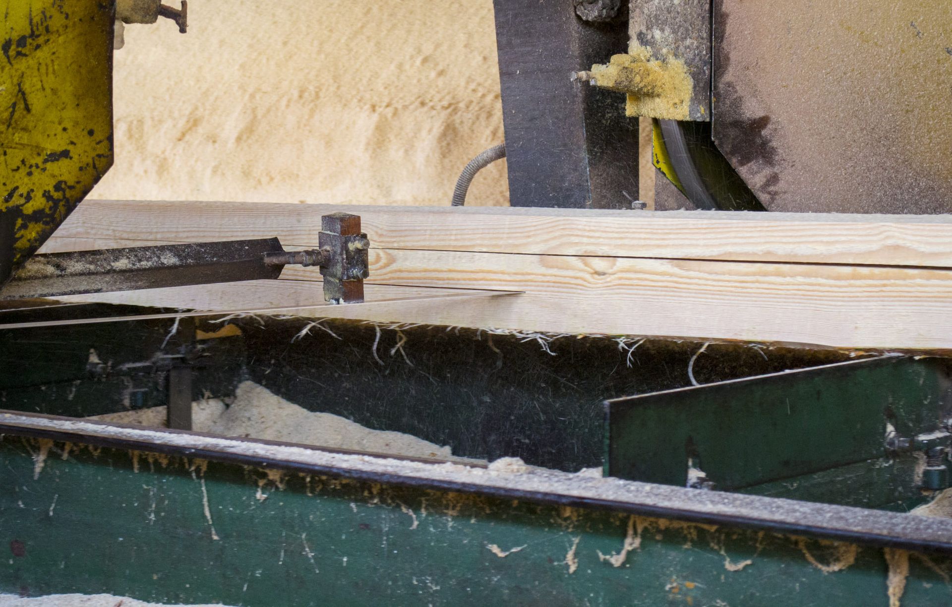 A machine is cutting a piece of wood on a conveyor belt
