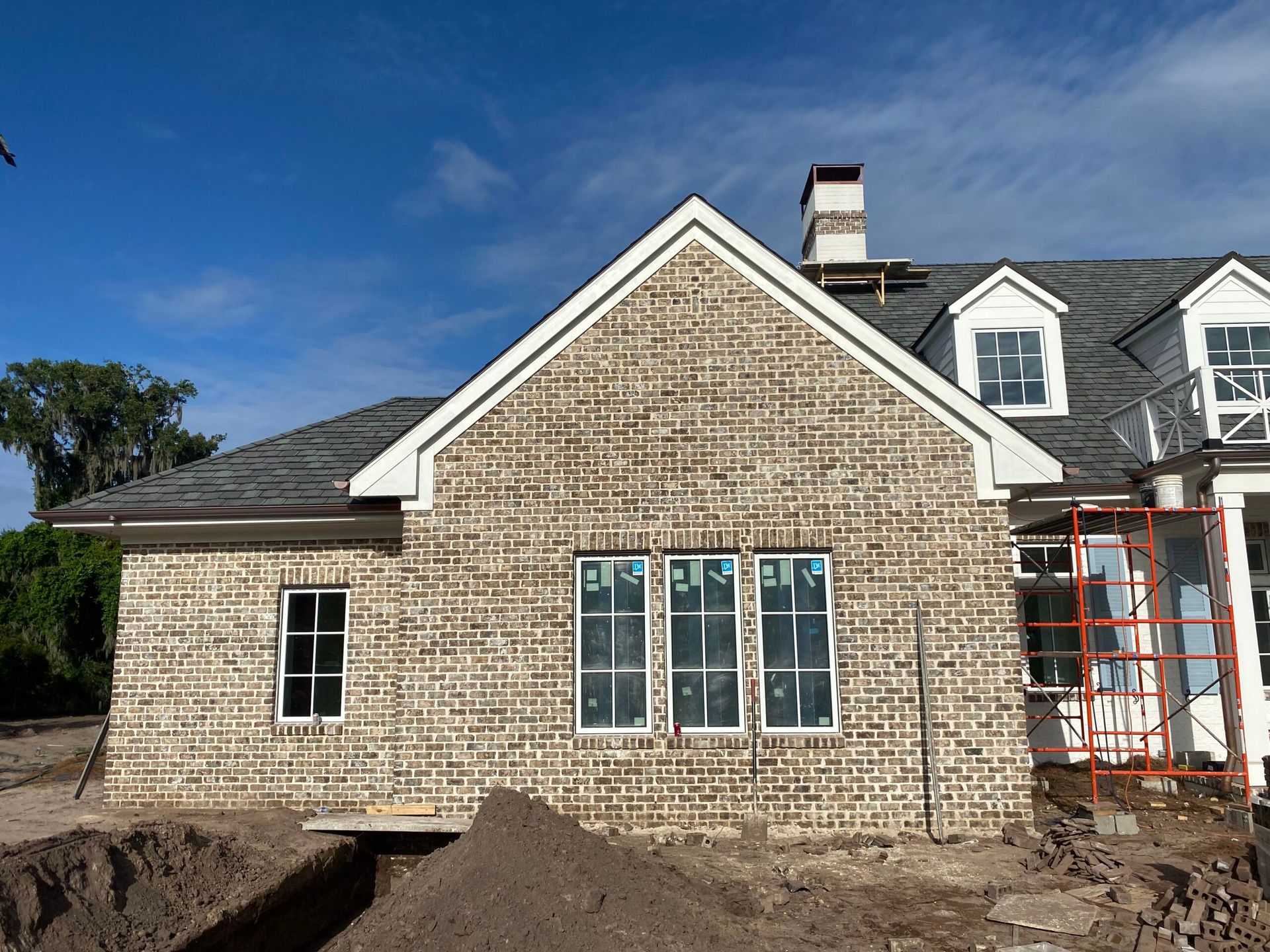 A large brick house under construction with a lot of windows