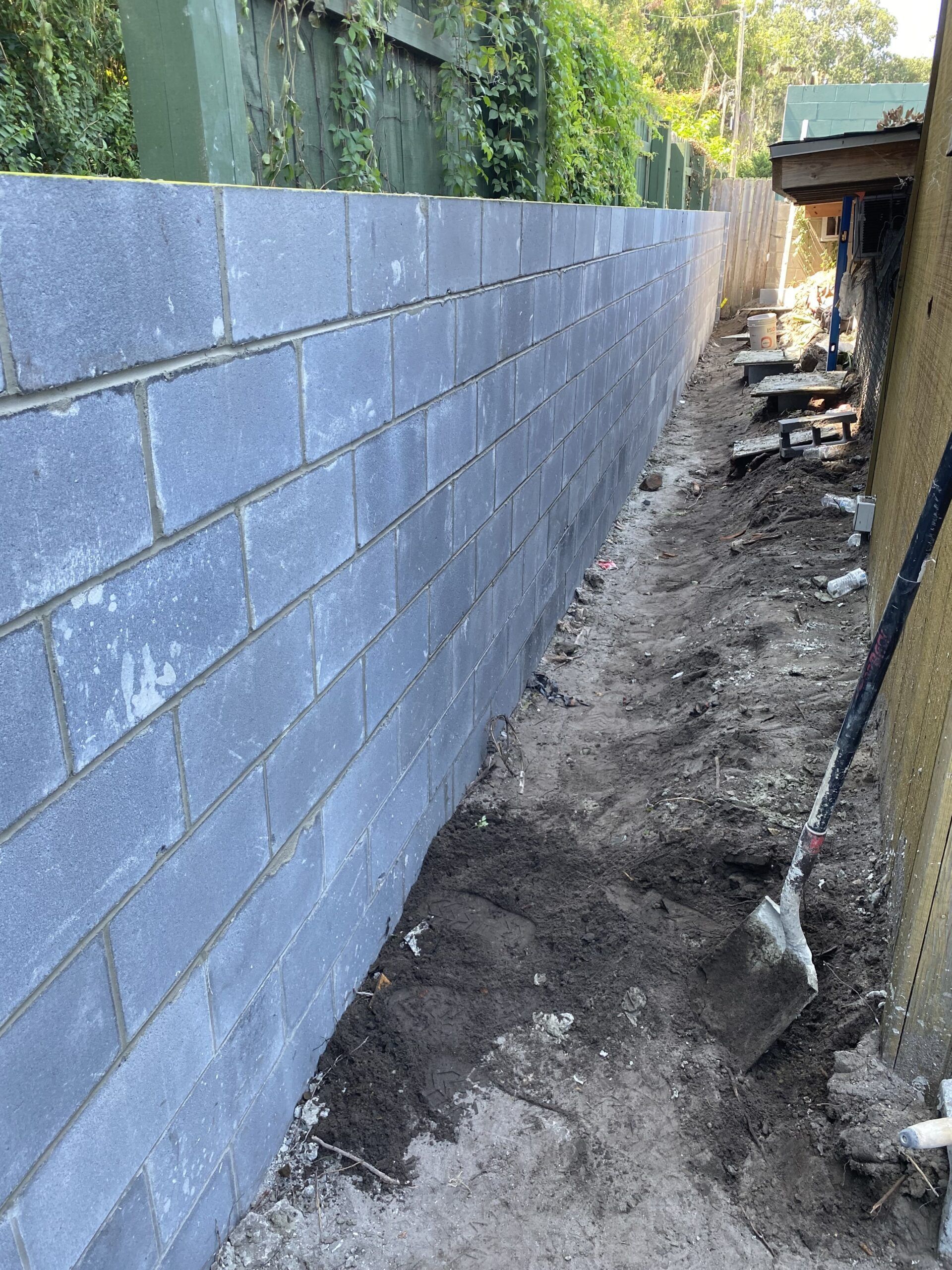 A brick wall is being built next to a house.