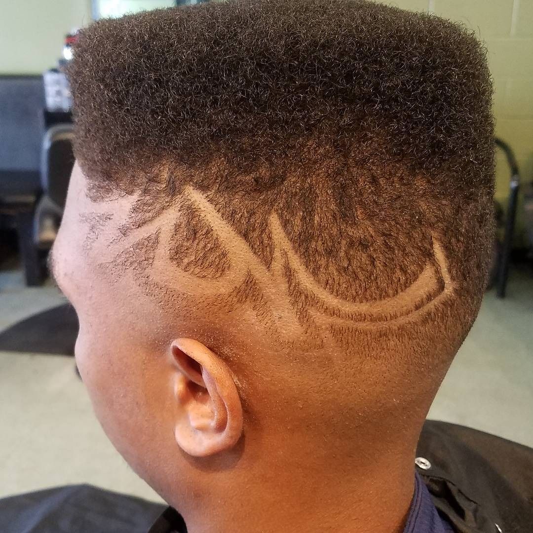 Close-up of a short haircut with a high fade and shaved curved design on the side.