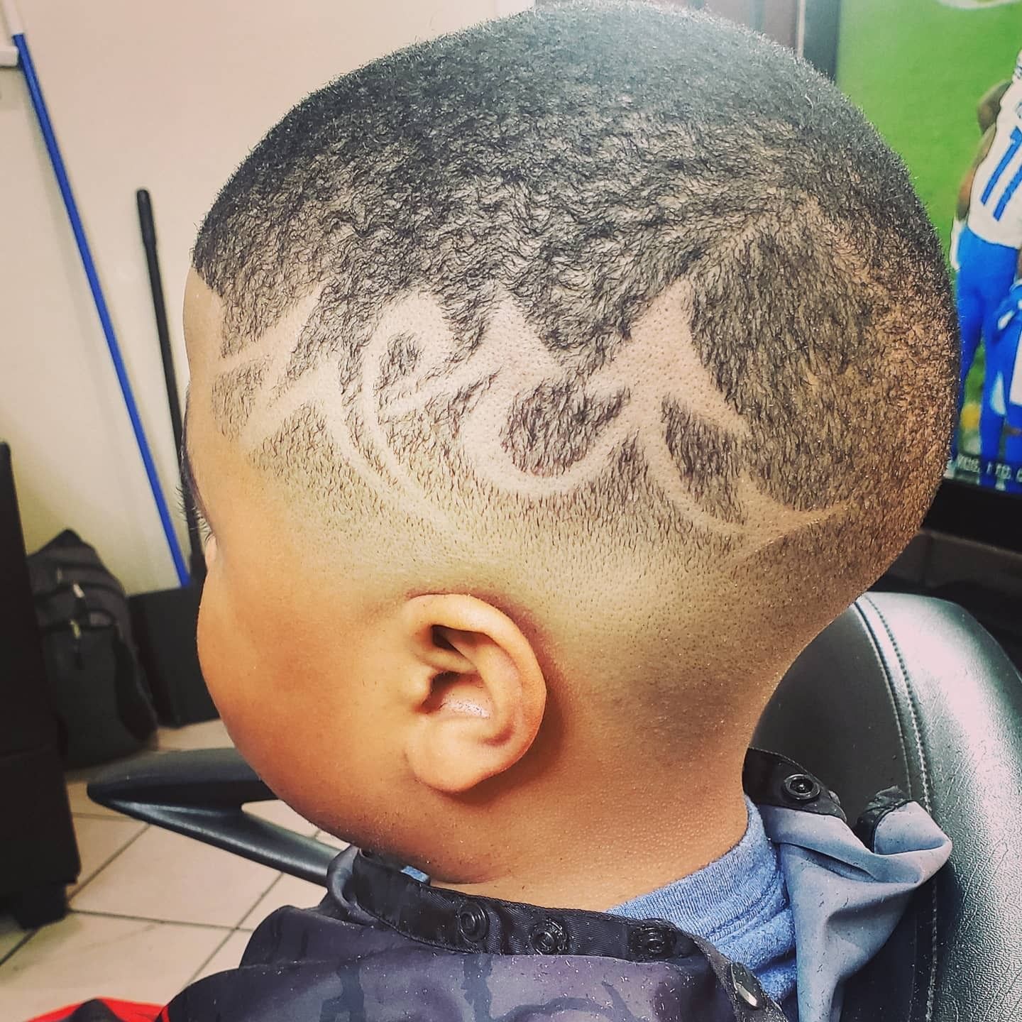 Close-up of a fresh fade haircut with a shaved lightning pattern on the side.