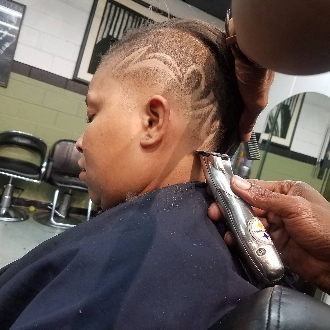 Person getting a haircut with clippers in a barbershop