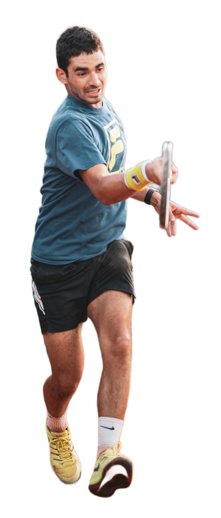 Tennis player in a blue shirt lunges to hit a ball with a racket and yellow shoes.