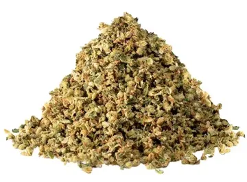 Pile of dried green-brown herbs or cannabis buds on a white background