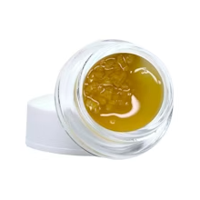 Open jar of amber gel with white lid on a white background