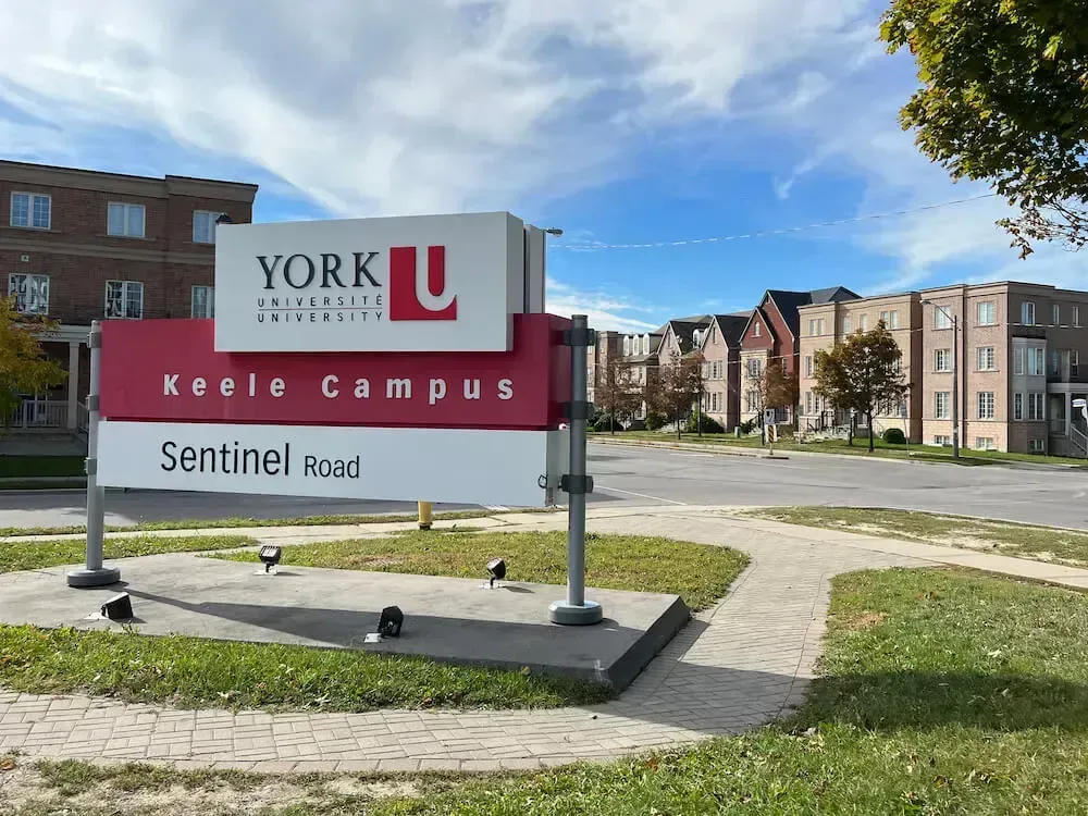 York University Keele Campus sign beside Sentinel Road on a sunny day