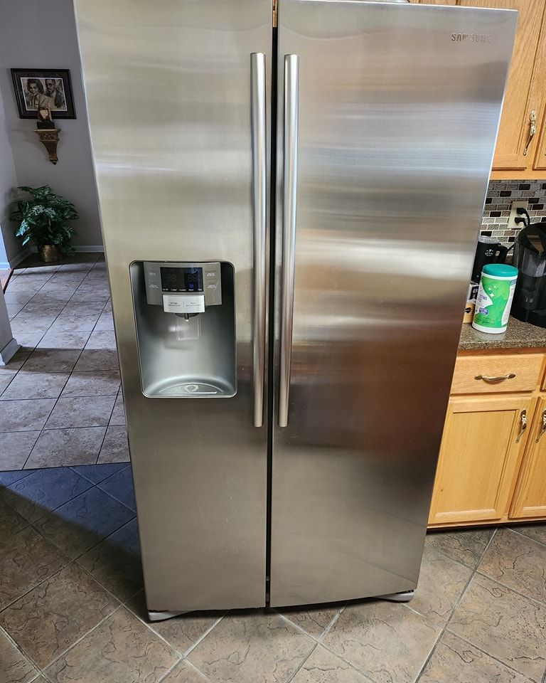 A stainless steel refrigerator is sitting in a kitchen next to a counter.