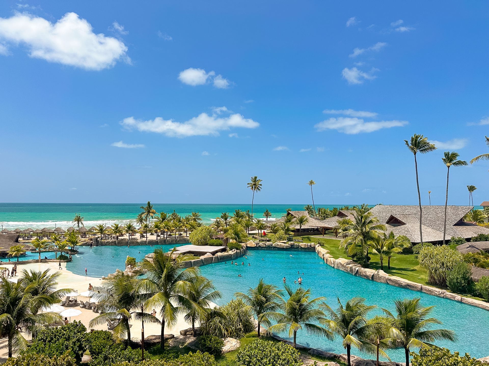 Enotel Porto de Galinhas, resort all inclusive com piscinas, coqueiros e vista para o mar.