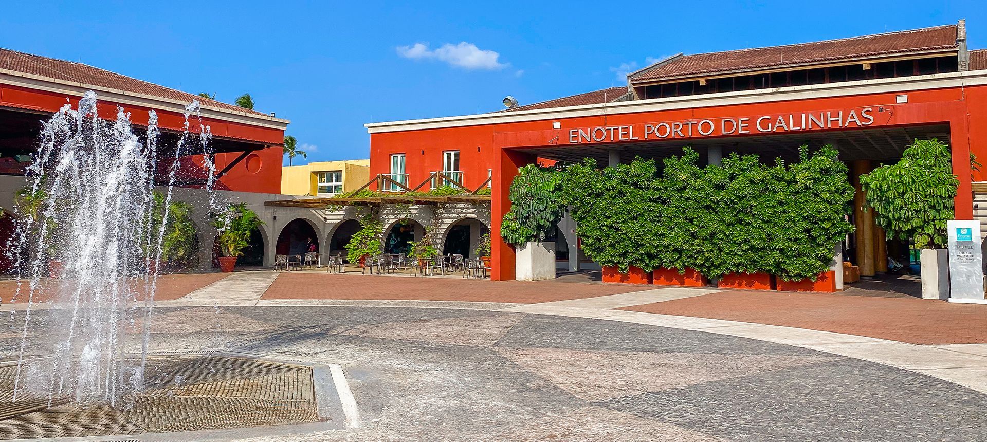 Main resort entrance with a water fountain and a red building facade.