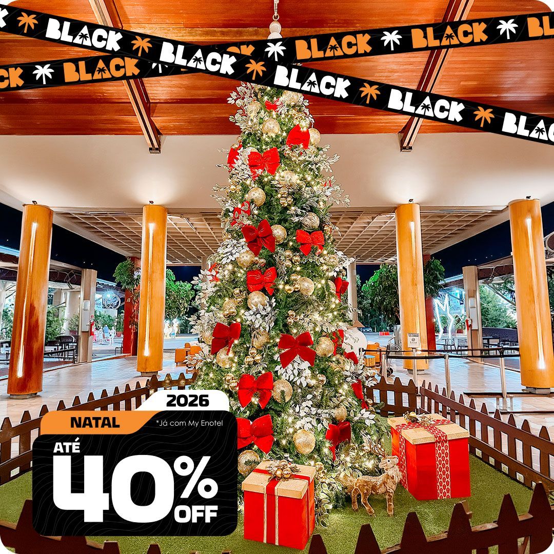 Árvore de Natal decorada no saguão do resort Enotel, com faixas da promoção de Black Friday e um selo anunciando até 40% de desconto para pacotes de Natal de 2026.