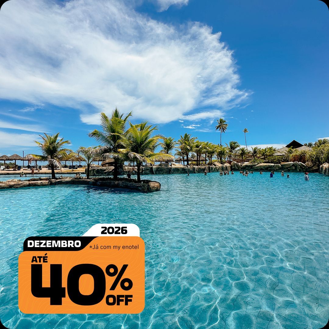Ampla piscina do resort Enotel em Porto de Galinhas, cercada por coqueiros sob um céu azul ensolarado. A imagem possui o selo da promoção My Black com até 40% de desconto para reservas em dezembro de 2026