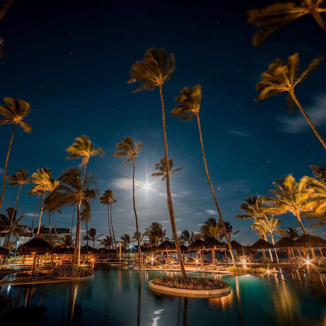 Promoção de Réveillon no Enotel Porto de Galinhas com vista noturna da piscina iluminada do resort.