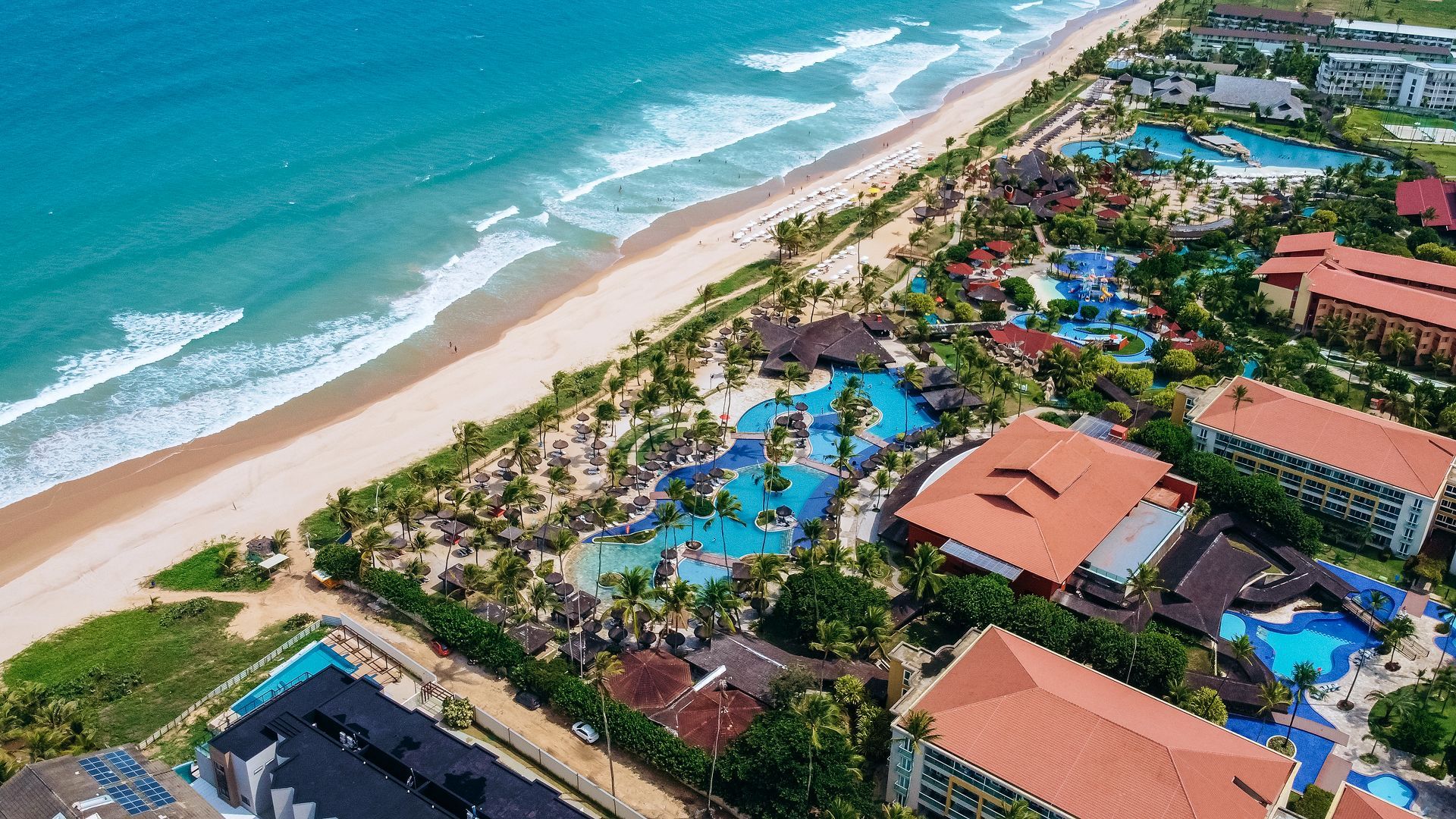 Estrutura completa do parque aquático infantil com toboáguas coloridos, escorregadores e balde interativo na piscina rasa do resort Enotel Porto de Galinhas.