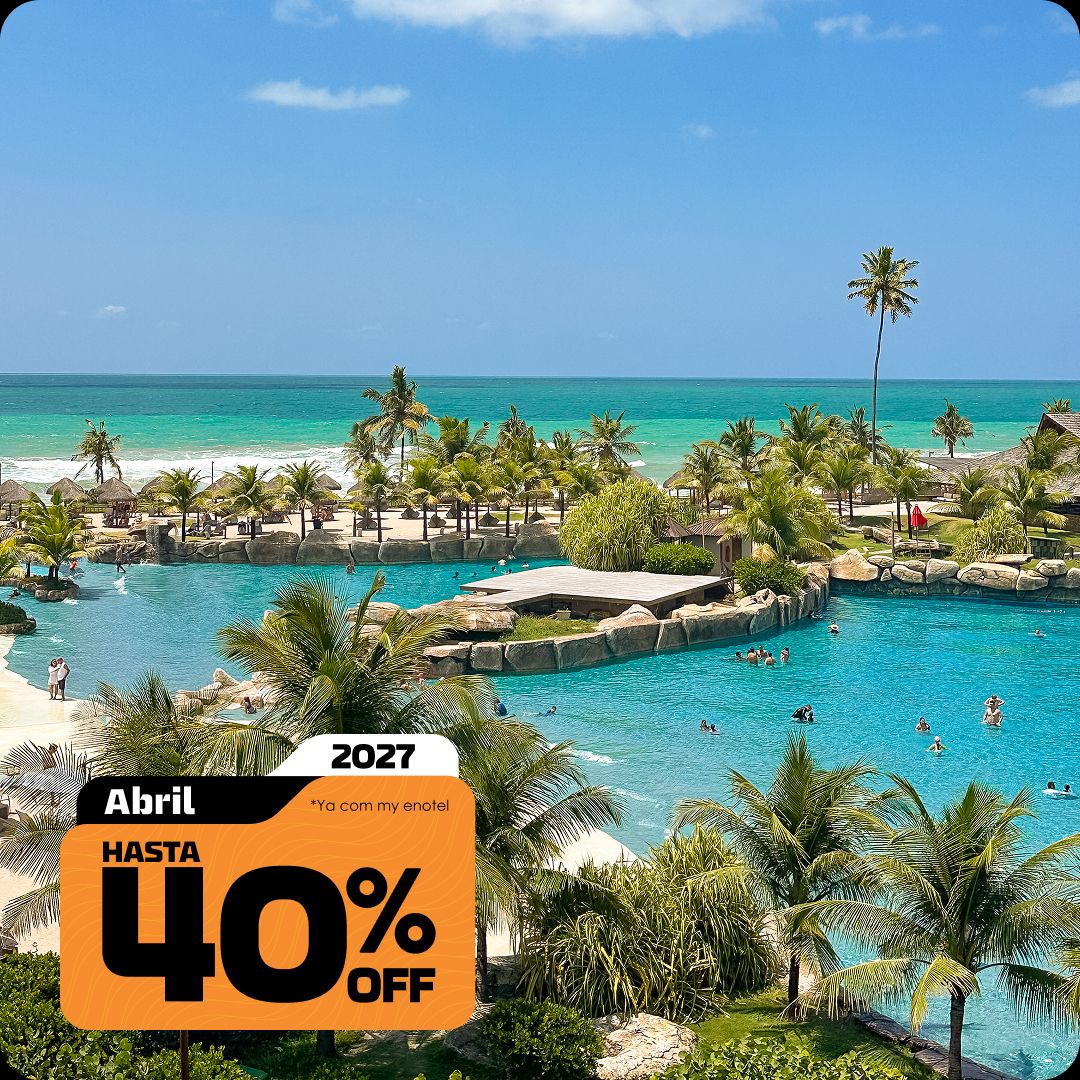 Vista aérea ampla das piscinas do resort Enotel, cercadas por coqueiros e áreas de lazer, com o mar verde-esmeralda de Porto de Galinhas ao fundo. A imagem contém o selo da promoção My Black com até 40% de desconto para reservas em abril de 2027