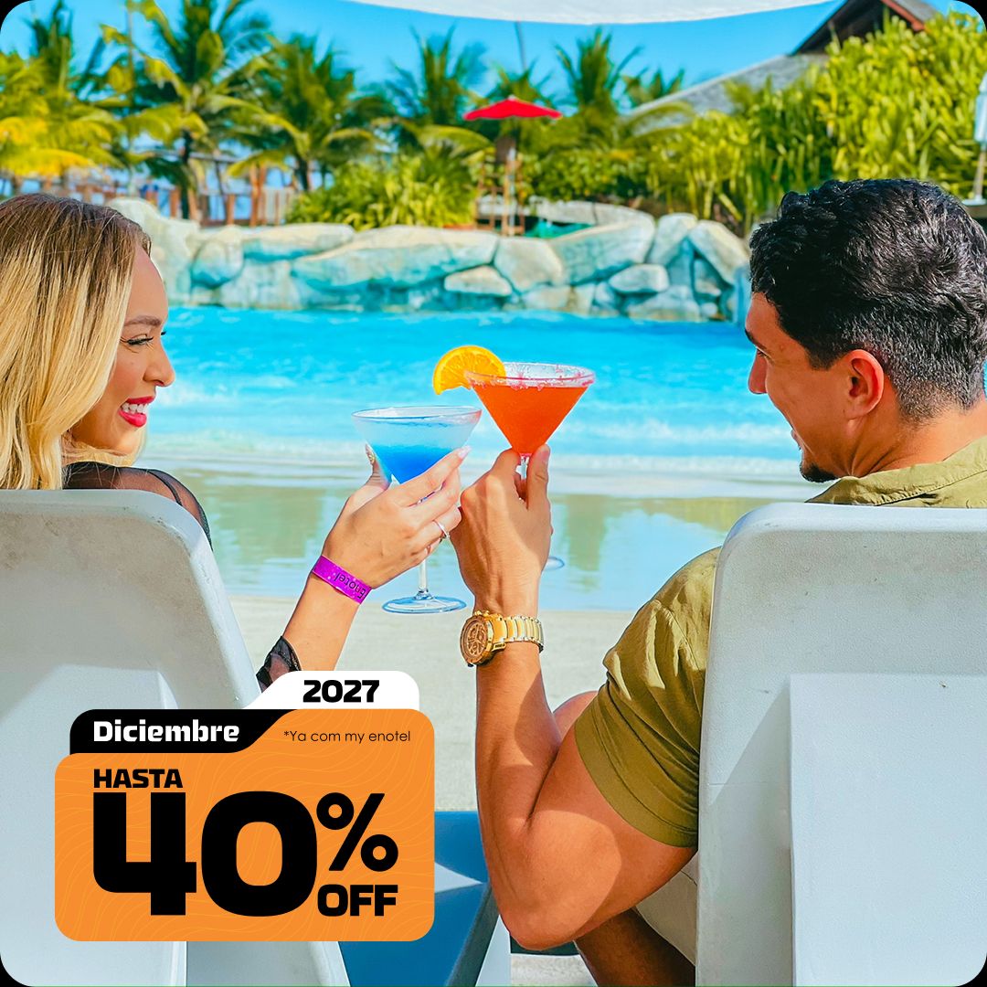 Casal sorrindo e brindando com drinks coloridos enquanto relaxam em espreguiçadeiras à beira da piscina do resort Enotel. A imagem exibe o selo da promoção My Black com até 40% de desconto para reservas em dezembro de 2027.