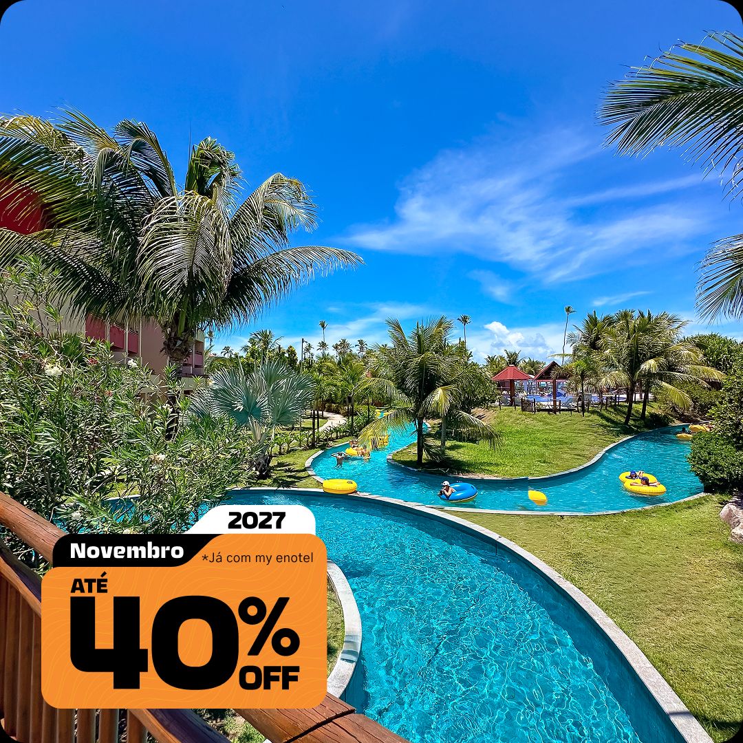 Vista a partir de uma varanda para o rio lento de águas cristalinas do resort Enotel. Pessoas relaxam em boias amarelas cercadas por jardins e coqueiros sob um céu azul. A imagem apresenta o selo da promoção My Black com até 40% de desconto para reservas em novembro de 2027.