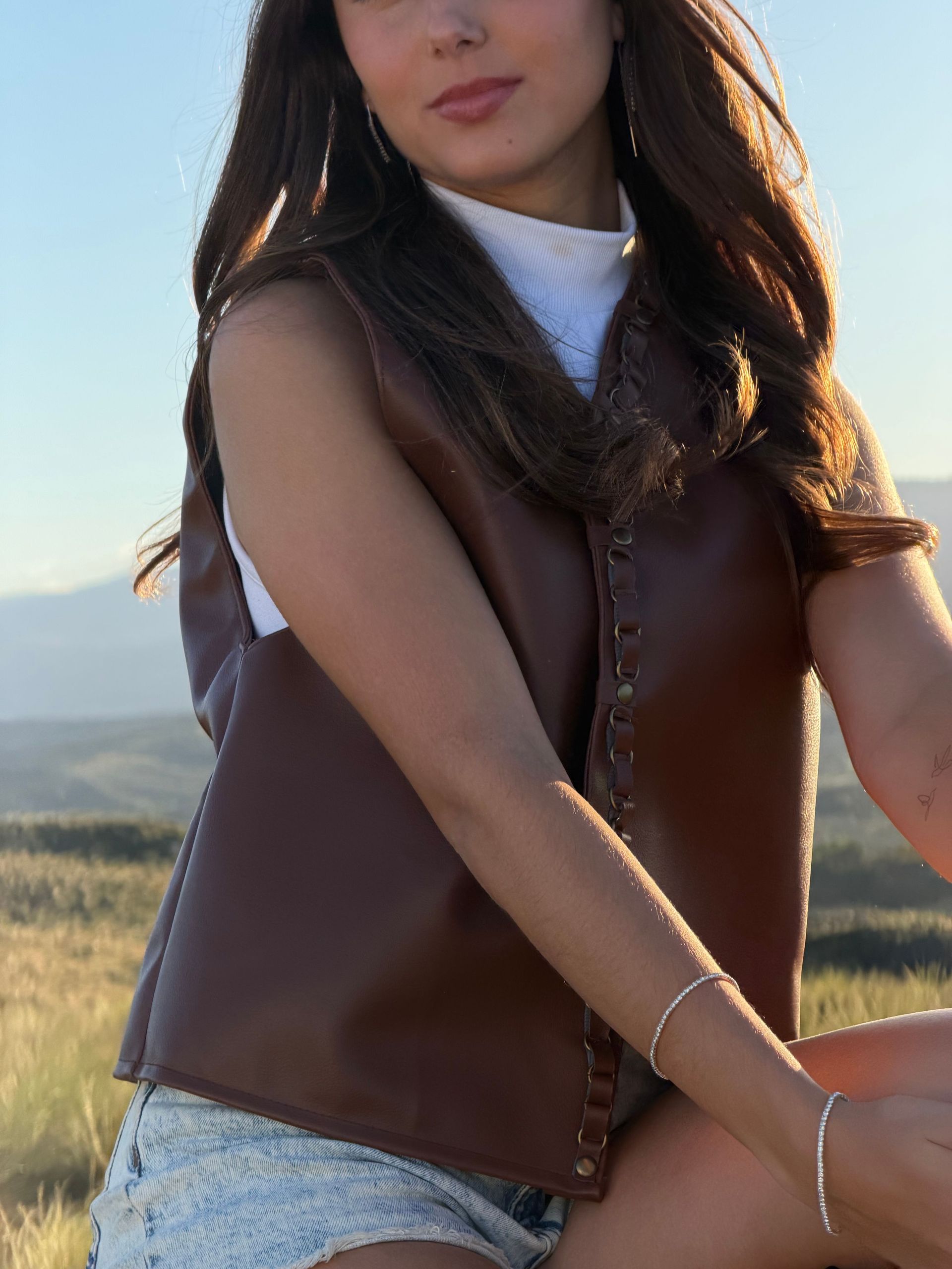 Una mujer con pantalones cortos de mezclilla y botas de vaquero