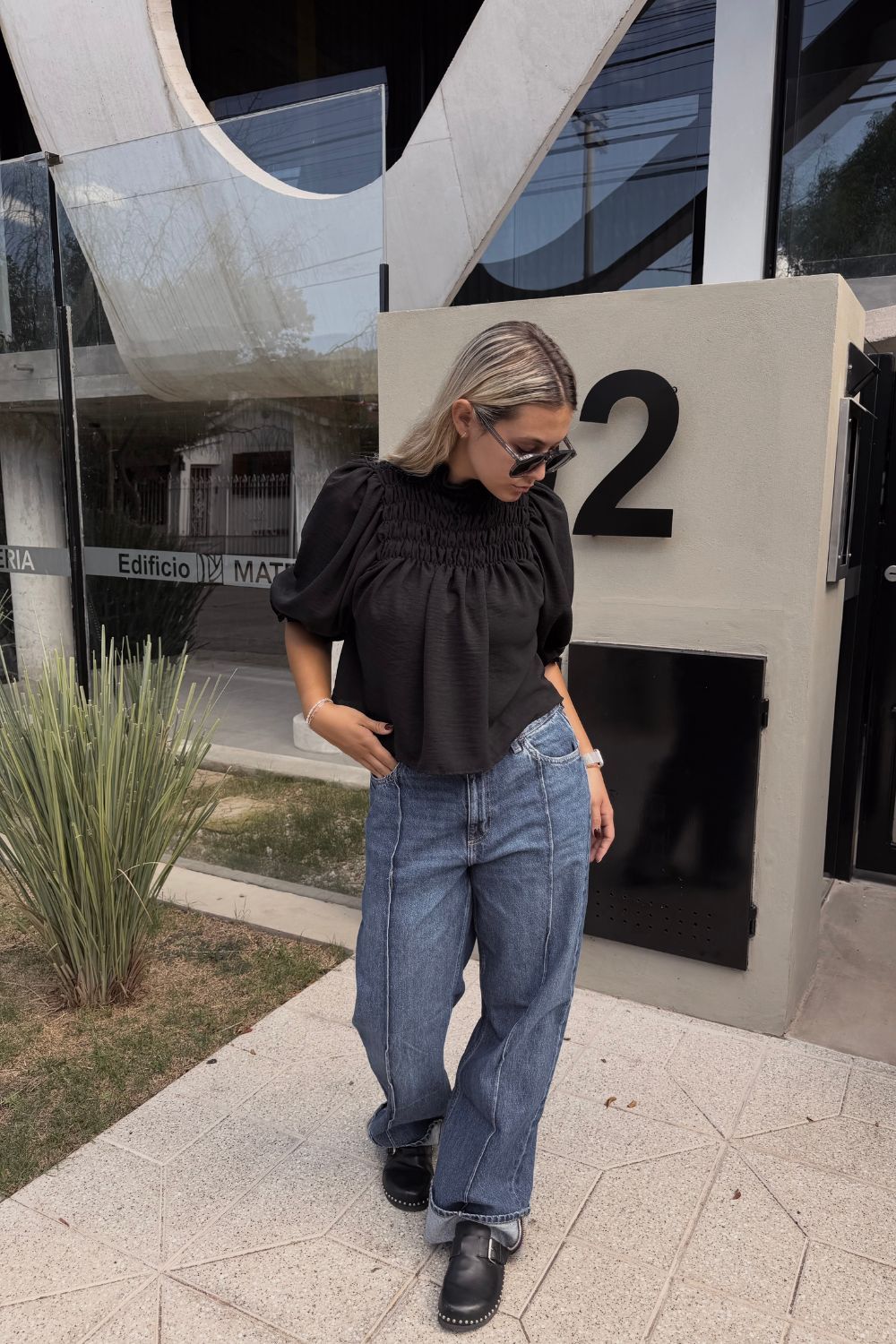 camiseta negra y pantalones vaqueros azules.
