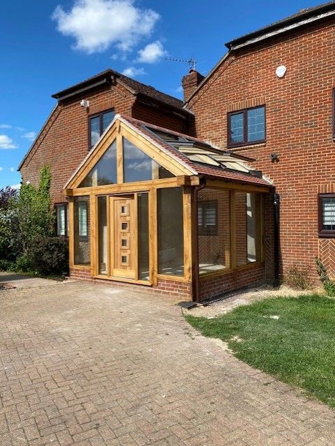A brick house with a wooden porch in front of it.